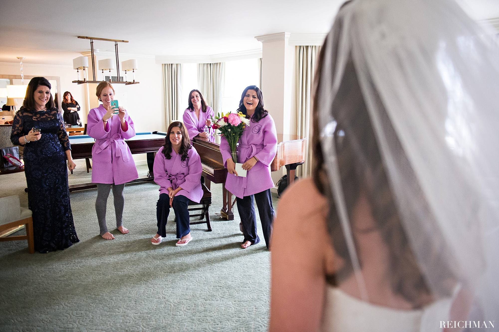 Bride revealing dress to bridesmaids