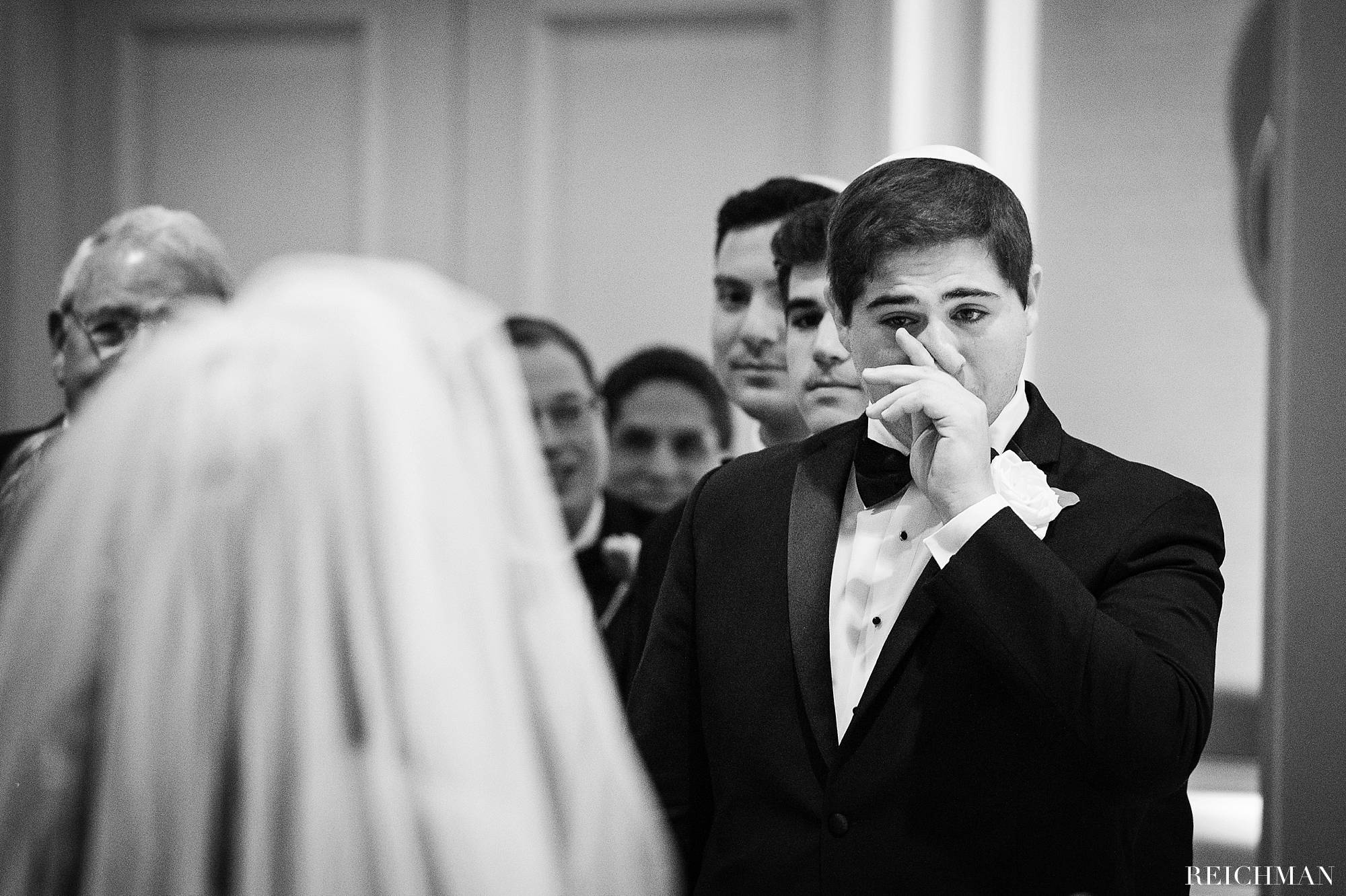 Groomsman crying during wedding ceremony